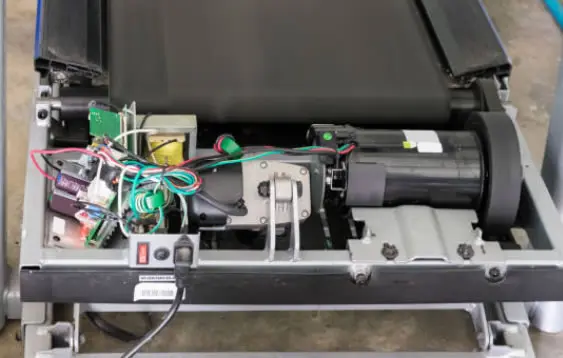 Perbaikan motor treadmill oleh teknisi — pengecekan dinamo dan karbon brush